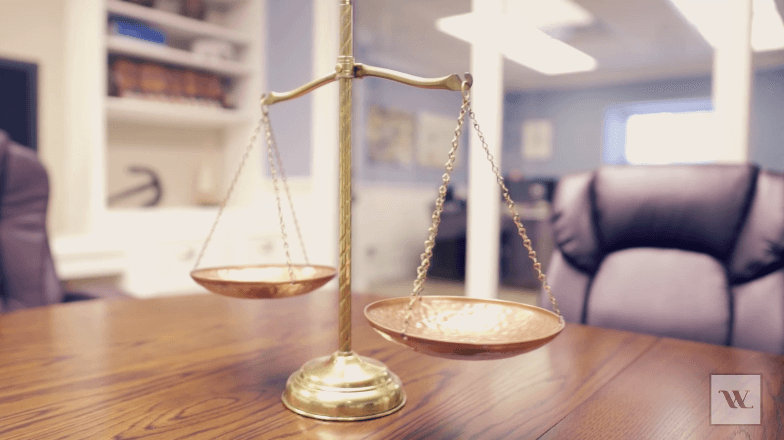 a wooden table with a scale and a chair in the background