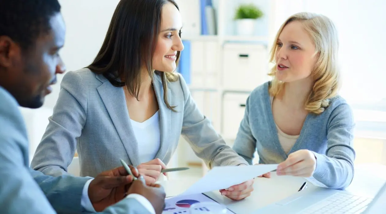 Two women and a man looking at a piece of paper.