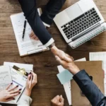 Two securities fraud attorneys in Clearwater, Florida, shaking hands across a table