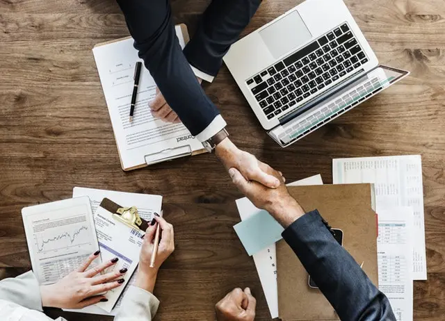 Two securities fraud attorneys in Clearwater, Florida, shaking hands across a table