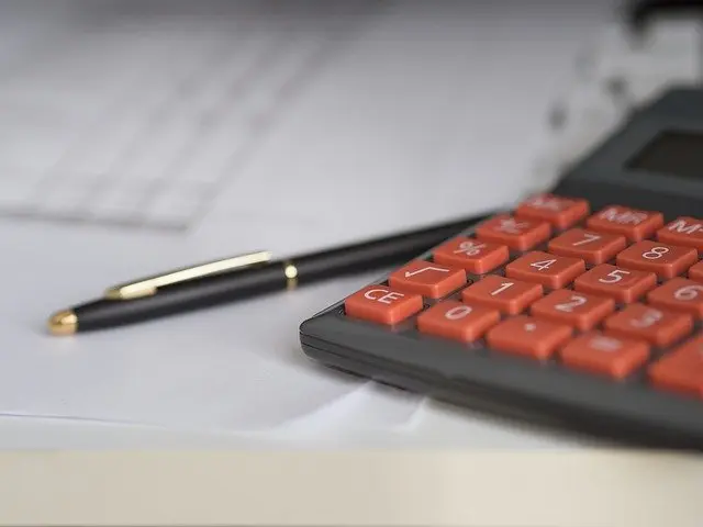 A pen and calculator next to paperwork about National Healthcare Properties