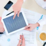 Two people looking at a tablet that contains data about variable annuity securities fraud claims