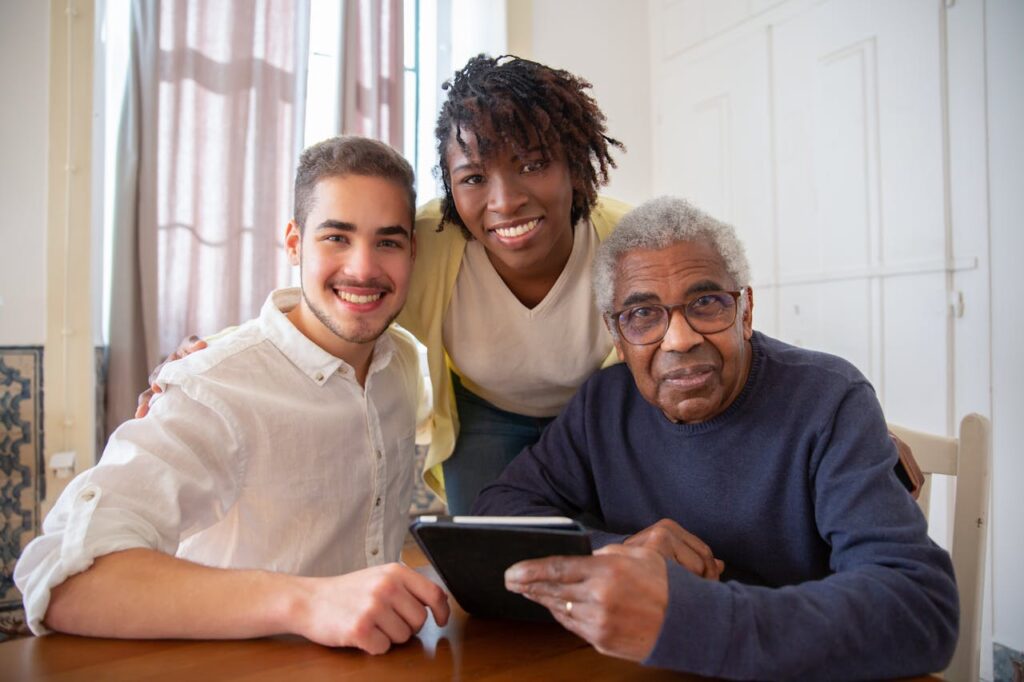 Two younger people explaining FINRA 4512 and elder fraud to a grandparent