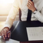 An attorney sitting at a desk speaking to a client about Next Level Holdings