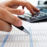 A person using a pen and calculator to mark information about Nashville, Tennessee, securities fraud attorneys