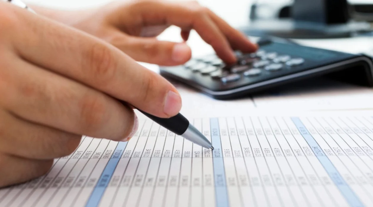 A person using a pen and calculator to mark information about Nashville, Tennessee, securities fraud attorneys