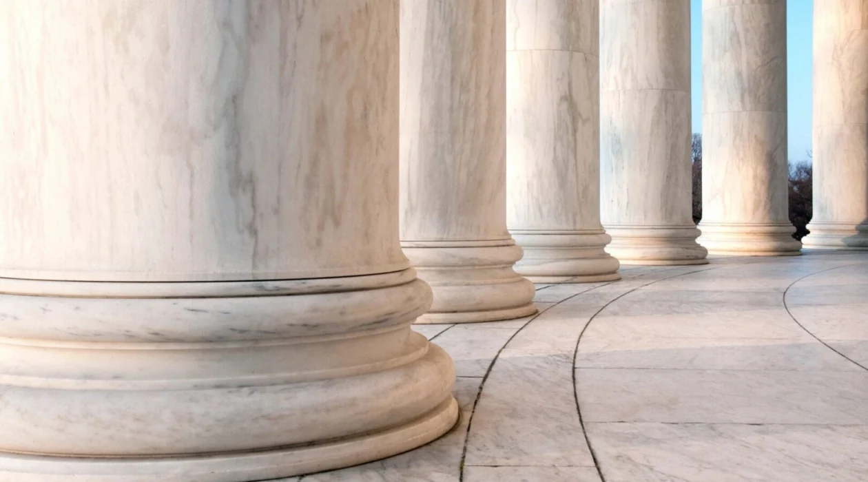 Courthouse columns representing the legal process for investors asking how long FINRA arbitration takes?